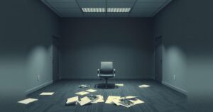 Symbolic representation of job terminations with an empty office, scattered files, and a solitary chair under dim lighting.
